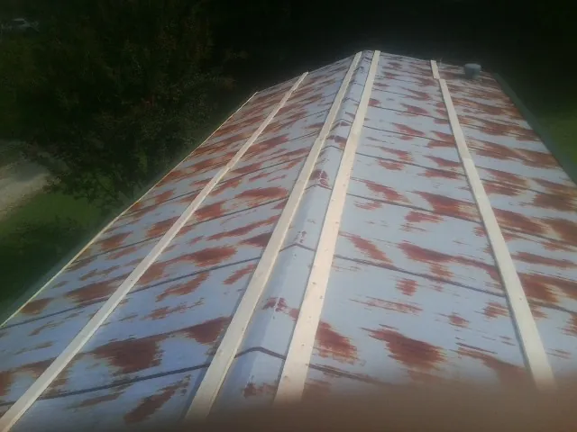 Rusted metal roof panels with new wood purlins before replacement — Storm Damage Roof Repair in Eugene by Roofing Brothers