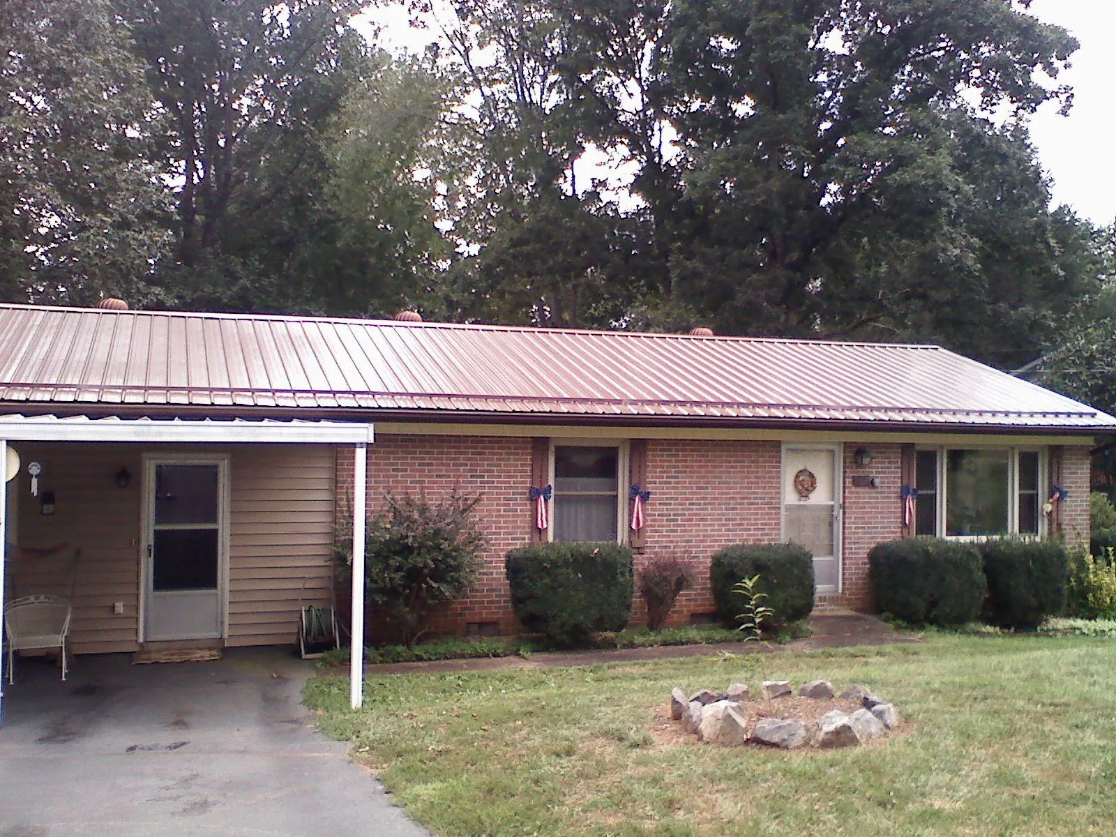 Bronze metal roof and carport on a brick ranch home — Roof Repair work by our crew in Eugene